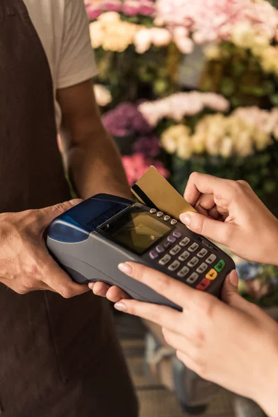 Image recadrée du client payant pour des fleurs avec carte de crédit en magasin — Photo de stock