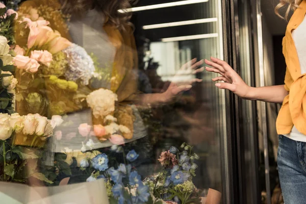 Imagem cortada de menina tocando vitrine de loja de flores — Fotografia de Stock
