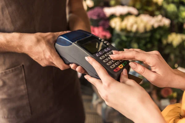 Imagen recortada del cliente que paga con tarjeta de crédito en la tienda de flores e ingresando el código del perno — Stock Photo