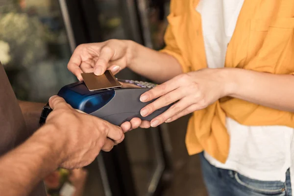 Imagem cortada do cliente que paga com cartão de crédito pelo pagamento contactless na loja da flor — Fotografia de Stock