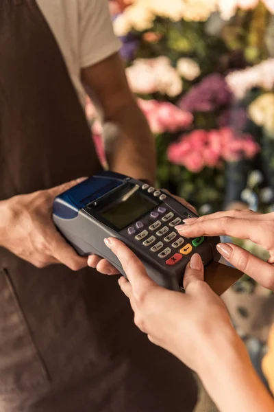 Image recadrée du client payant par carte de crédit au magasin de fleurs et entrant le code PIN sur le terminal de paiement — Photo de stock