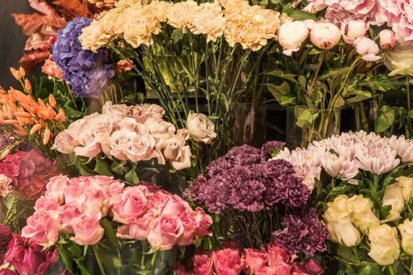 Belles roses colorées et fleurs d'oeillet à la boutique de fleurs — Photo de stock