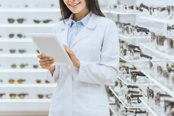 Vista ritagliata di ottico utilizzando tablet digitale al lavoro nel negozio oftalmico — Foto stock