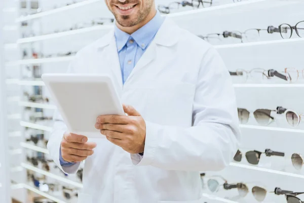 Vista recortada del optometrista en capa blanca usando tableta digital en óptica - foto de stock