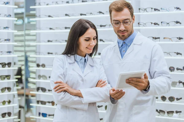 Two professional oculists working and using digital tablet in optica — Stock Photo