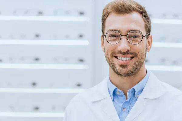 Retrato de optometrista profesional guapo en gafas en óptica - foto de stock