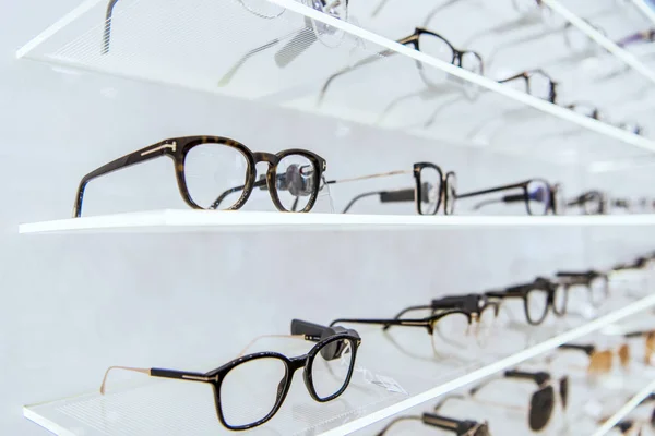 Enfoque selectivo de estantes blancos con gafas de moda en la tienda oftálmica - foto de stock