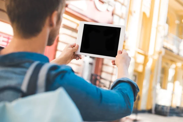 Plan recadré de jeune homme à l'aide d'une tablette avec écran blanc sur la rue — Photo de stock