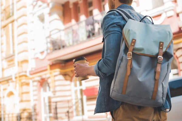 Plan recadré de jeune homme avec sac à dos et café pour aller marcher dans la rue — Photo de stock