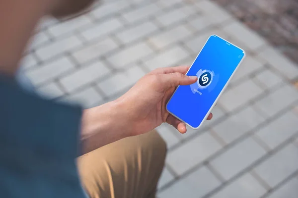 Recortado disparo de hombre usando teléfono inteligente con shazam en la pantalla — Stock Photo