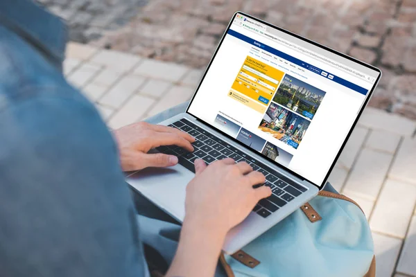 Cropped shot of man using laptop with booking website on street — Stock Photo