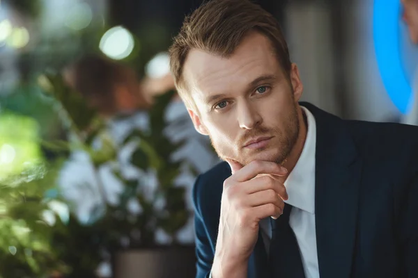 Portrait of pensive businessman looking at camera in cafe — Stock Photo