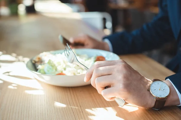 Tiro cortado de homem de negócios à mesa com almoço servido no restaurante — Fotografia de Stock