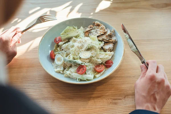 Vista parcial del hombre de negocios y servido ensalada para el almuerzo en la mesa en el restaurante - foto de stock