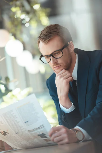Retrato de homem de negócios em óculos lendo jornal no café — Fotografia de Stock