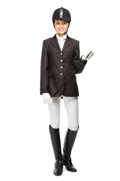 Smiling young horsewoman in uniform holding horseman stick isolated on white — Stock Photo