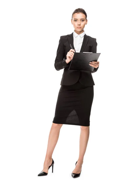 Attractive young businesswoman in suit with clipboard looking at camera isolated on white — Stock Photo