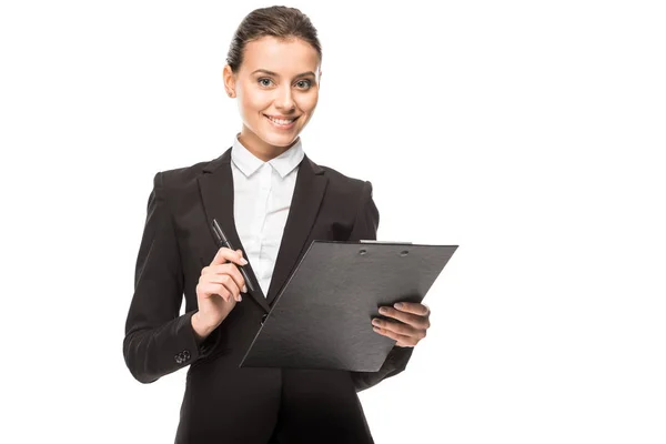 Smiling young businesswoman in suit with clipboard looking at camera isolated on white — Stock Photo