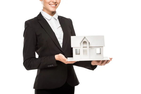 Cropped shot of smiling young businesswoman holding miniature house model isolated on white — Stock Photo