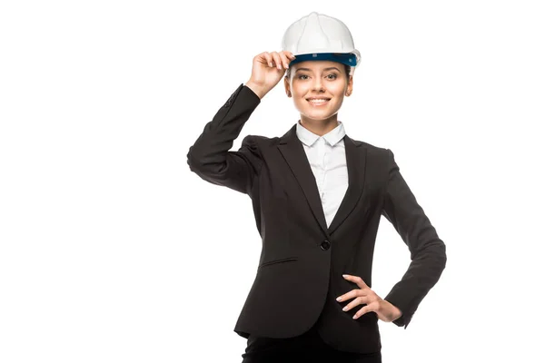 Heureuse jeune architecte femme en casque et costume regardant la caméra isolée sur blanc — Photo de stock