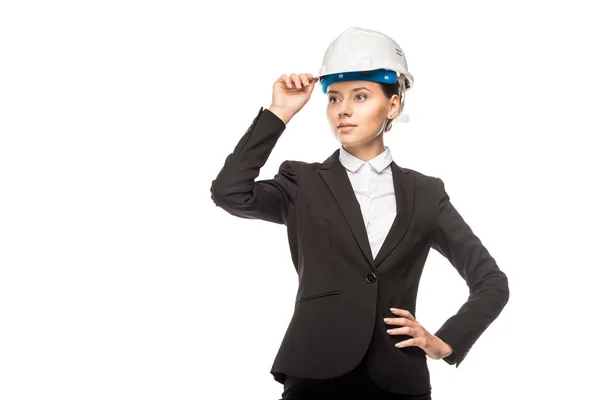 Confiant jeune architecte femme en casque et costume regardant loin isolé sur blanc — Photo de stock