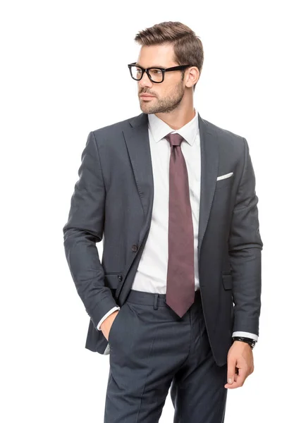 Attrayant jeune homme d'affaires en costume et lunettes et regardant loin isolé sur blanc — Photo de stock
