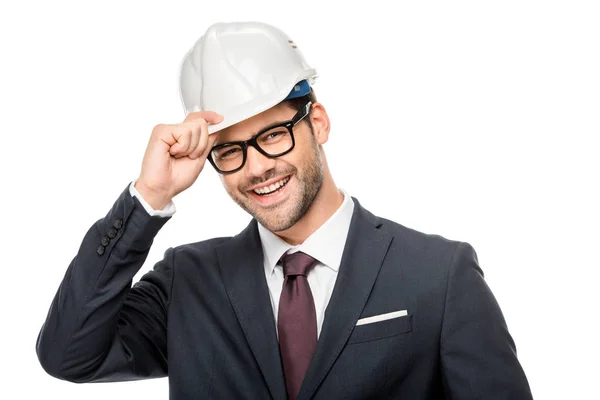 Portrait of laughing young male architect adjusting hard hat isolated on white — Stock Photo