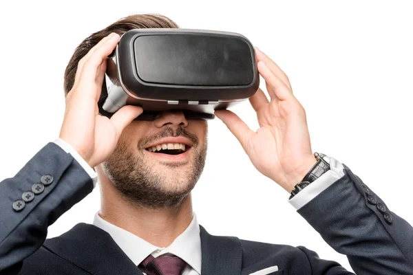 Smiling young businessman using virtual reality headset isolated on white — Stock Photo