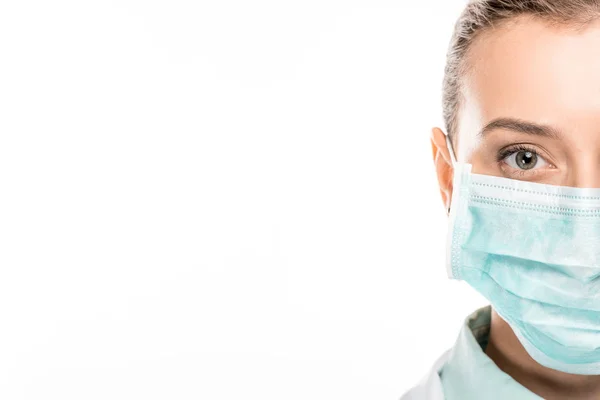 Imagem cortada de jovem médica em máscara médica olhando para a câmera isolada no branco — Fotografia de Stock