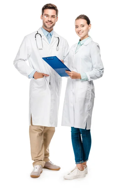 Happy female doctor holding clipboard while her male colleague standing near isolated on white — Stock Photo