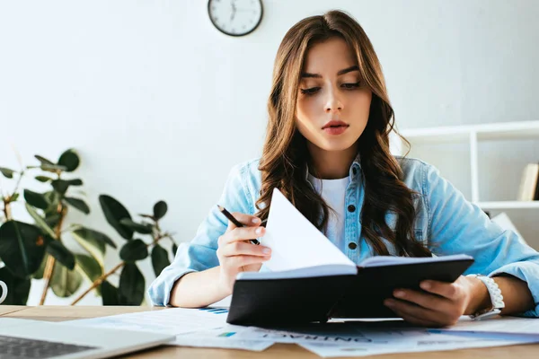 Ritratto di giovane donna d'affari con taccuino sul posto di lavoro con documenti e laptop in ufficio — Foto stock