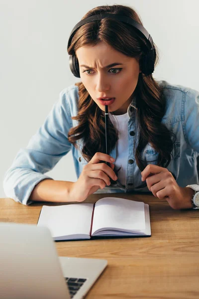 Mujer joven en auriculares que participan en webinar en la oficina - foto de stock