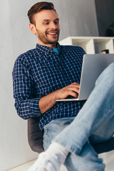 Улыбающийся бизнесмен с ноутбуком принимает участие в вебинаре в офисе — стоковое фото