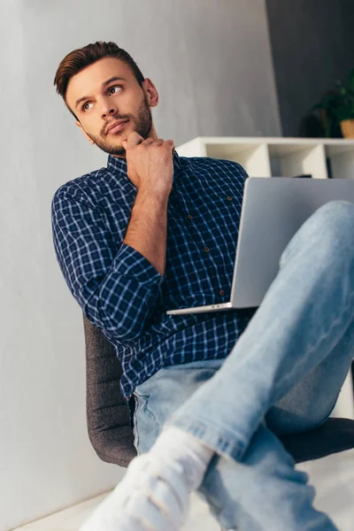 Pensive businessman with laptop taking part in webinar in office — Stock Photo