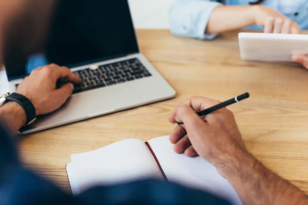 Cropped shot of business colleagues with laptop and tablet taking part in webinar in office — Stock Photo