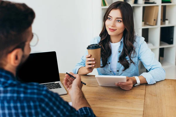 Colegas de negocios con ordenador portátil y tableta que participan en webinar en la oficina - foto de stock