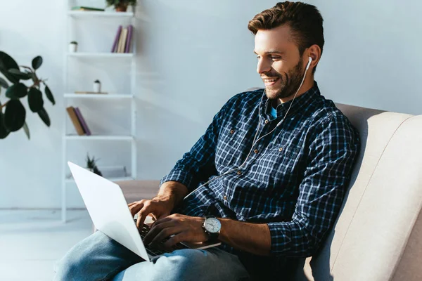 Uomo sorridente in auricolare che partecipa a webinar a casa — Foto stock