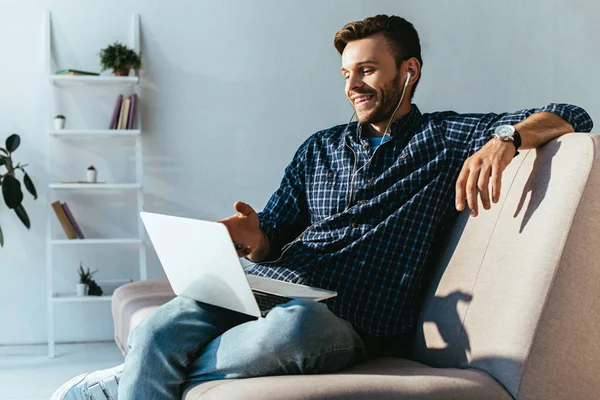 Cheerful man in earphones taking part in webinar at home — Stock Photo