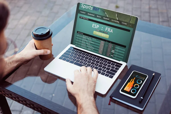 Immagine ritagliata di uomo utilizzando computer portatile con sportsbet al caffè di strada — Foto stock