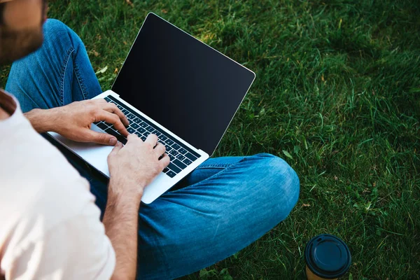 Imagem cortada do homem usando laptop com tela em branco no parque — Fotografia de Stock