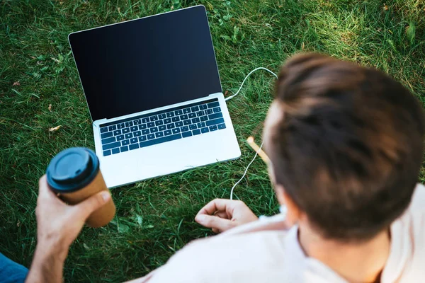 Visão de alto ângulo do homem usando laptop com tela em branco ao ar livre — Fotografia de Stock
