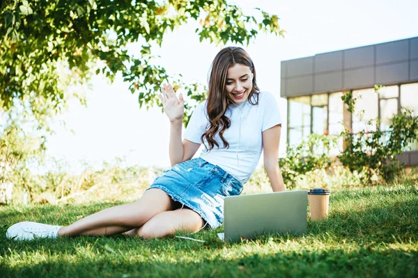 Belle fille prendre part à webinaire et saluer la main pendant la vidéoconférence — Photo de stock