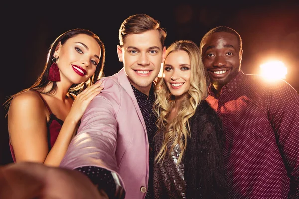 Smiling glamorous young multiethnic friends taking selfie — Stock Photo