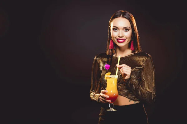 Брюнетка гламурна усміхнена дівчина з алкогольним коктейлем на чорному — стокове фото