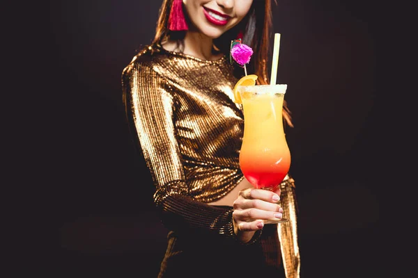 Cropped view of smiling girl holding glass with cocktail on black — Stock Photo