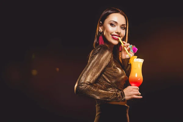 Beautiful glamorous girl drinking alcohol cocktail on black — Stock Photo