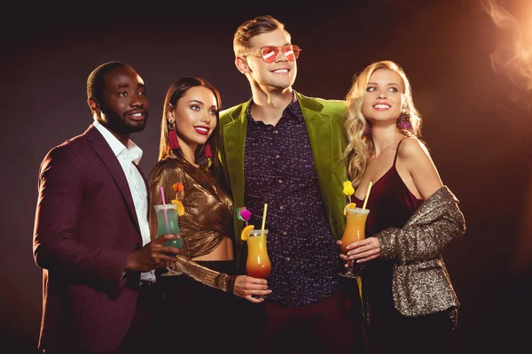 Happy luxury multiethnic friends holding glasses with alcohol cocktails — Stock Photo