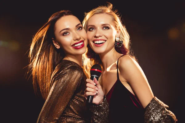 Attractive happy friends singing with microphone in karaoke — Stock Photo