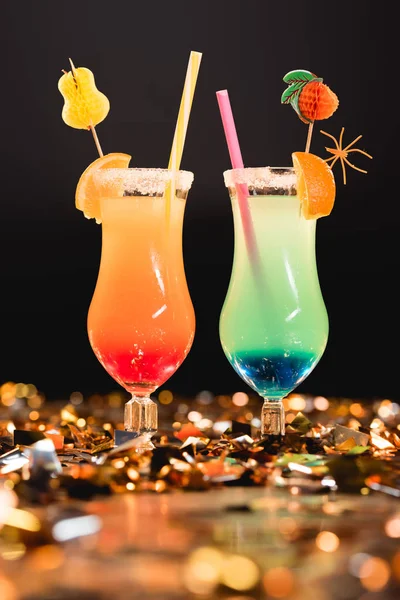 Gläser mit bunten Cocktails mit Strohhalmen auf goldenem Konfetti zum Feiern — Stockfoto