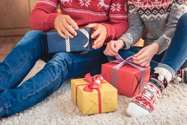 Imagem cortada de marido e mulher abrindo presentes de Natal em casa — Fotografia de Stock